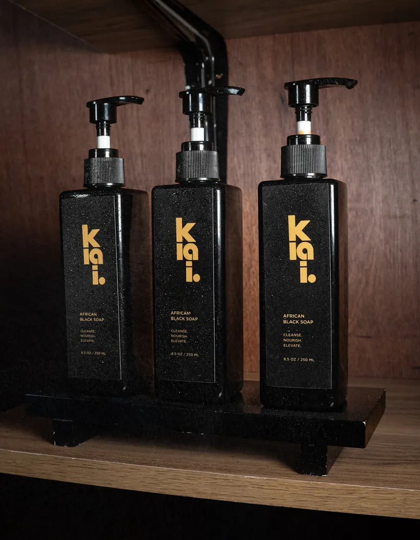Three klai. African Liquid Black Soap bottles on a wooden shelf display